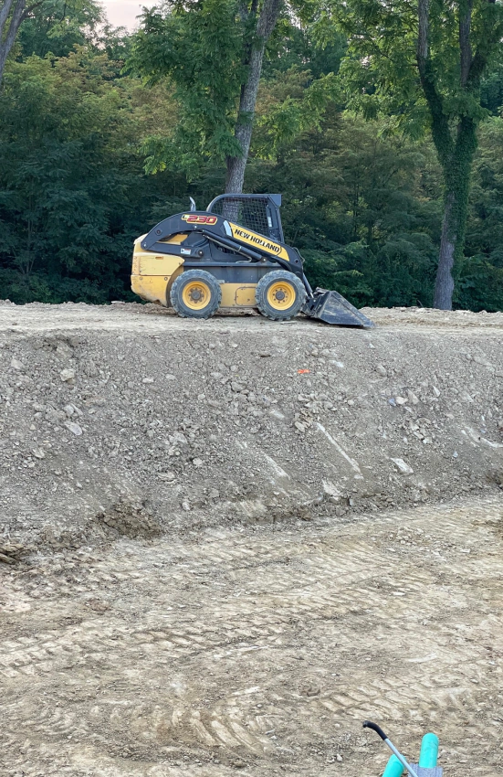a crawler loader on top of a pile of dirt
